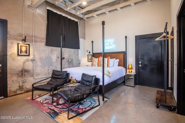 a bedroom with a bed and a painting on the wall