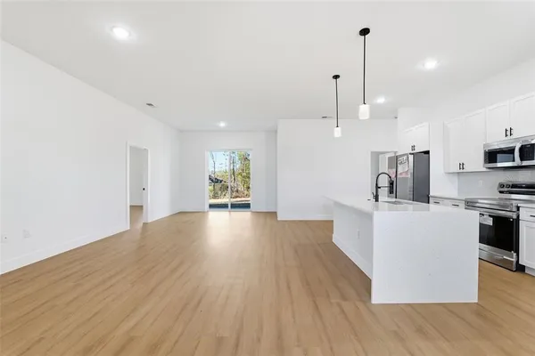 a kitchen with stainless steel appliances a sink a stove a microwave and cabinets