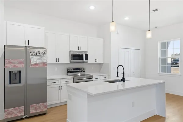a kitchen with stainless steel appliances a sink stove and refrigerator