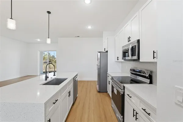 a kitchen with stainless steel appliances a sink stove and refrigerator