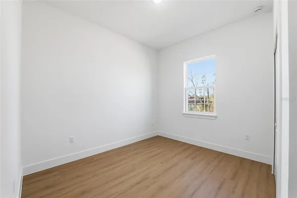 a view of an empty room with wooden floor