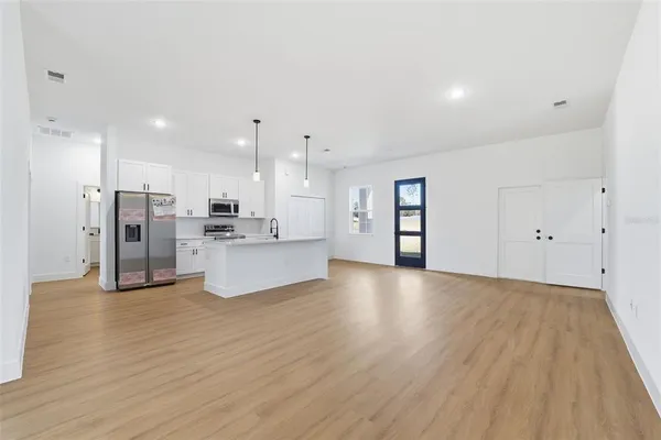 a view of kitchen with cabinets stainless steel appliances and wooden floor