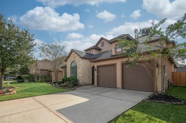 a front view of a house with a garden and trees