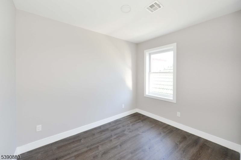 9 Watsessing Avenue, Unit 2R Bloomfield, NJ 07003 - Photo 11 of 14 an empty room with wooden floor and window