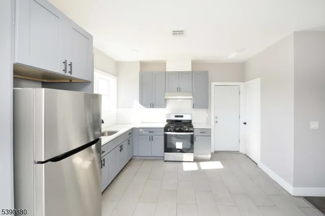 a kitchen with stainless steel appliances a refrigerator sink and stove