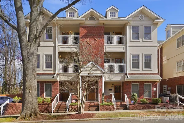 a front view of a residential apartment building with a yard
