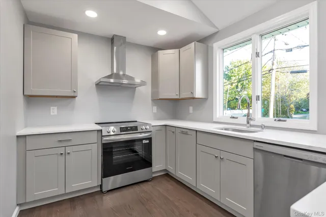 a kitchen with stainless steel appliances granite countertop a sink a stove and a window