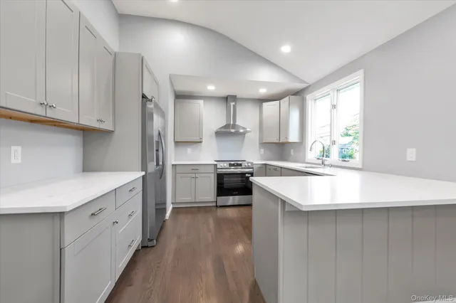 a kitchen with white cabinets appliances and window