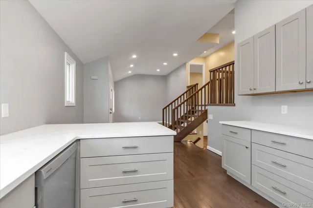 a kitchen with a white wooden floor and cabinets
