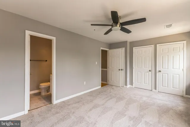 a view of empty room with wooden floor and ceiling fan