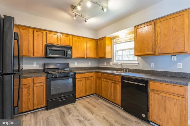 a kitchen with stainless steel appliances granite countertop a stove sink microwave and window