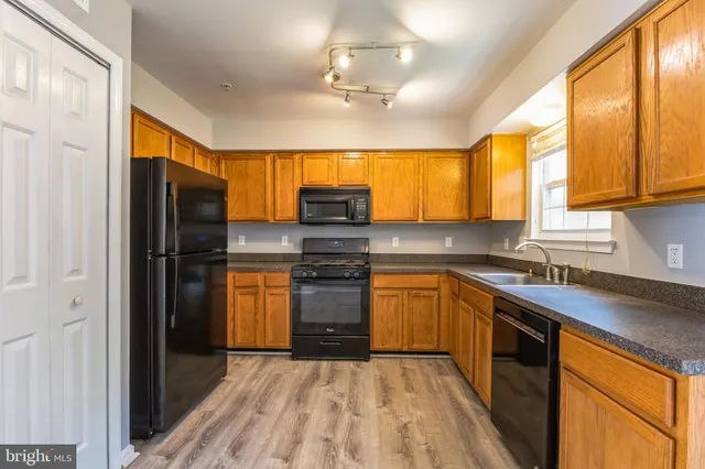 a kitchen with stainless steel appliances granite countertop a refrigerator and a sink