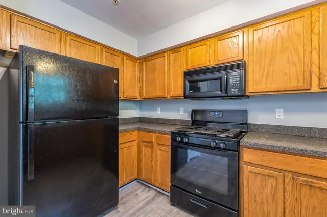 a kitchen with stainless steel appliances granite countertop wooden cabinets sink and a granite counter top