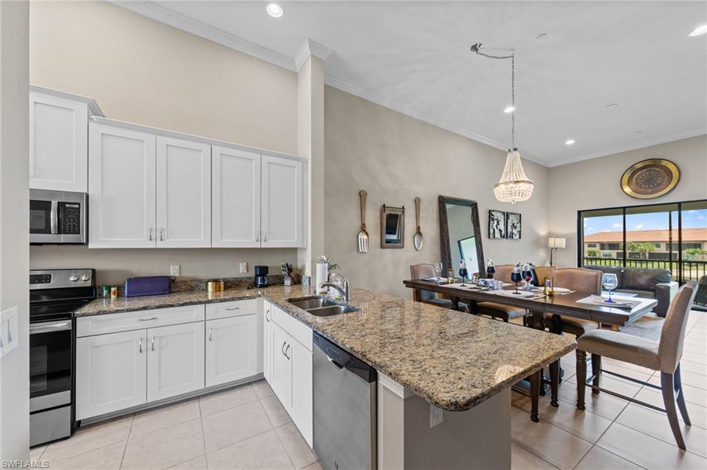 9366 Pocida Court, Unit 202 Naples, FL 34119 - Photo 7 of 44 a kitchen with stainless steel appliances granite countertop a sink and cabinets