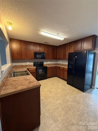a kitchen with stainless steel appliances granite countertop a stove refrigerator and cabinets