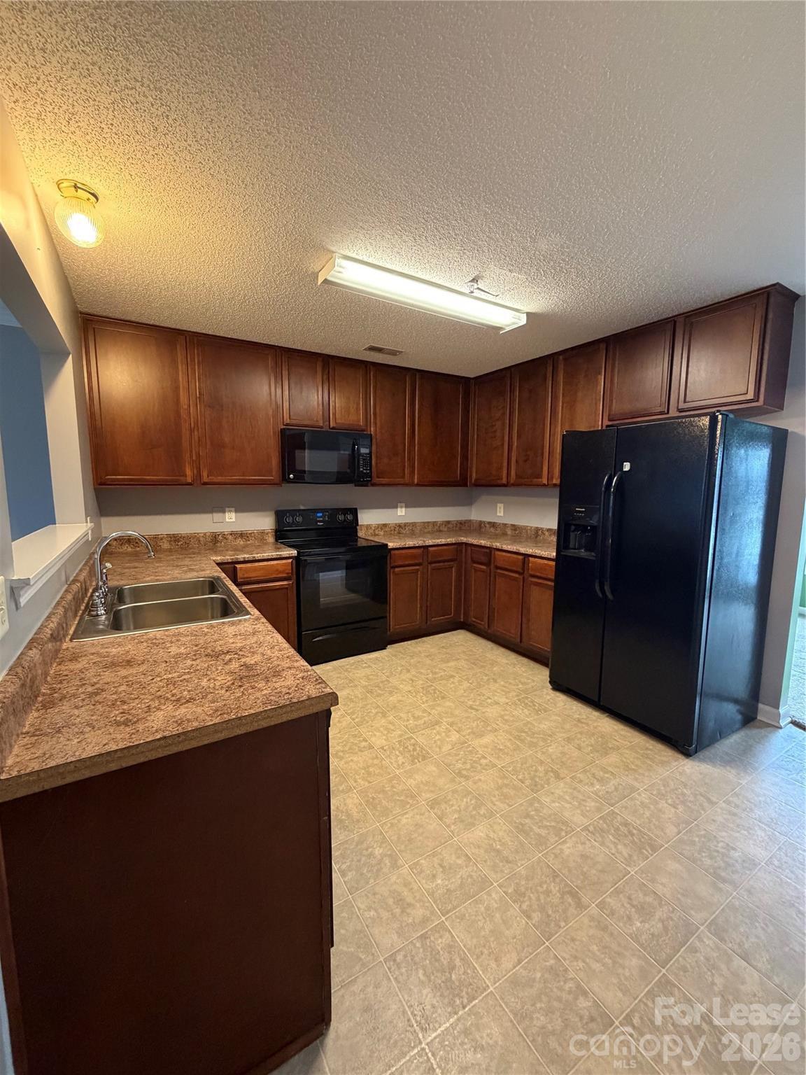 110 Steam Engine Drive, Unit 202 Mooresville, NC 28115 - Photo 6 of 26 a kitchen with stainless steel appliances granite countertop a stove refrigerator and cabinets