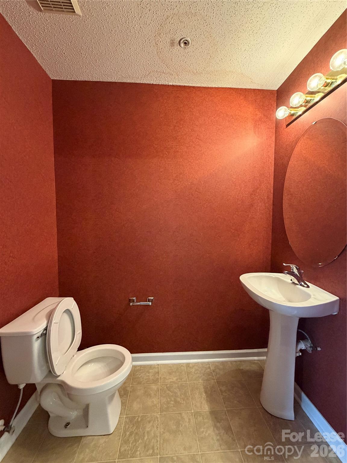 110 Steam Engine Drive, Unit 202 Mooresville, NC 28115 - Photo 7 of 26 a bathroom with a toilet a sink and mirror