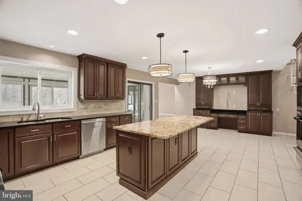 a kitchen with stainless steel appliances granite countertop a sink and a refrigerator