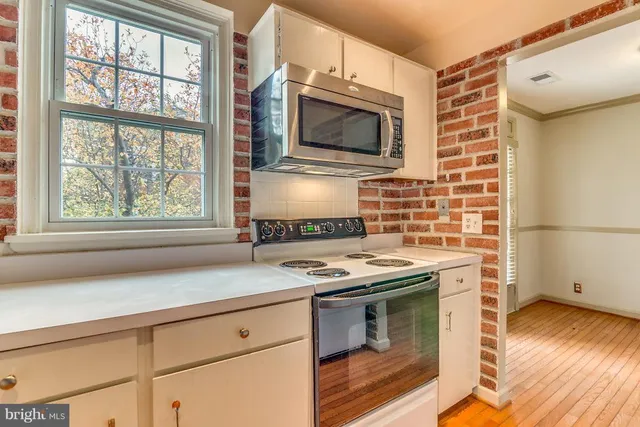 a kitchen with stainless steel appliances a stove and a microwave