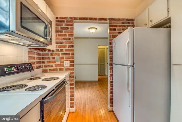a kitchen with a refrigerator and a stove top oven