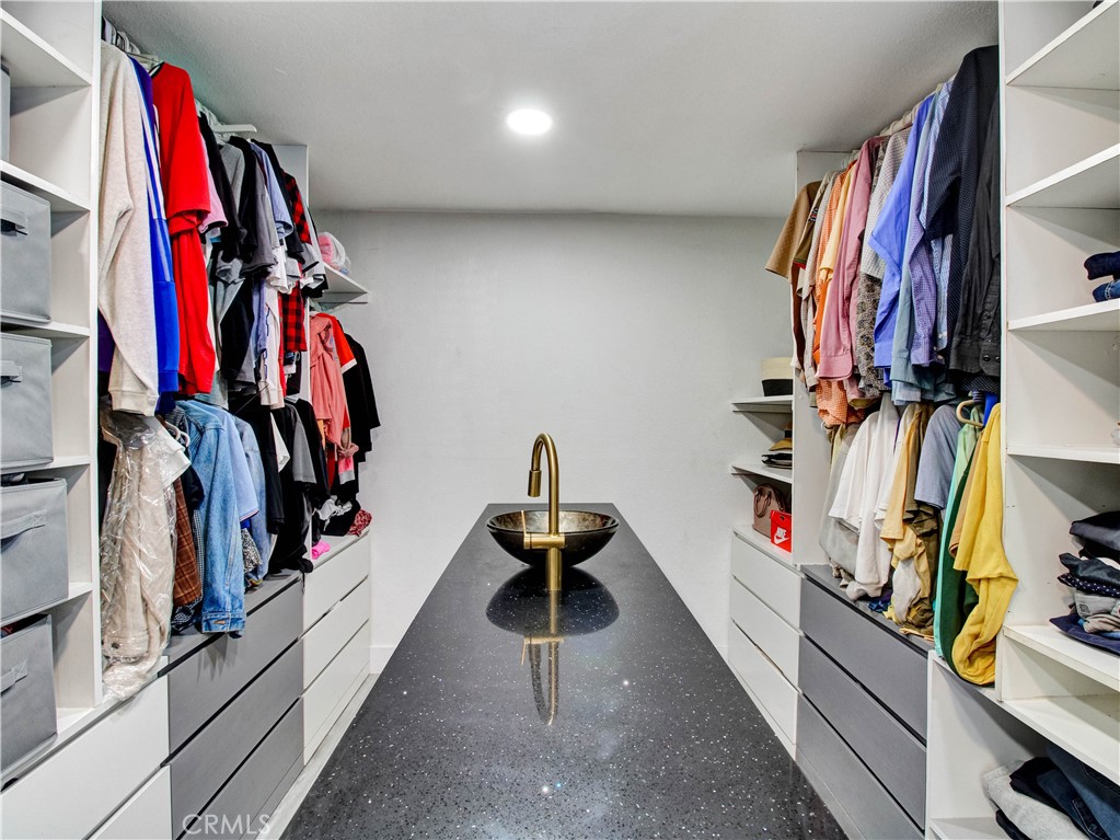 1025 South Riverside Avenue, Unit 26 Rialto, CA 92376 - Photo 21 of 27 a view of walk in closet with clothes and shoes