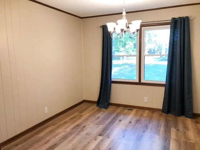 a view of a room with wooden floor and large window