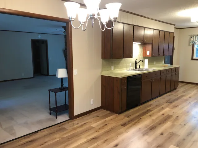 a kitchen with kitchen island granite countertop wooden cabinets and sink