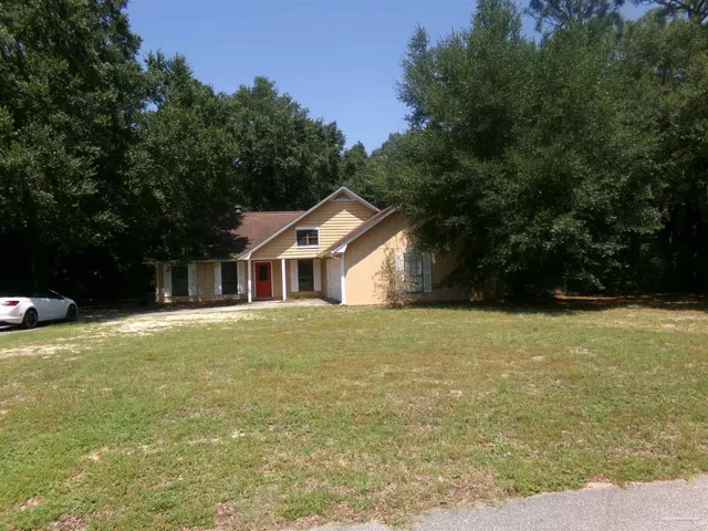 a yellow and red house sitting in middle of forest