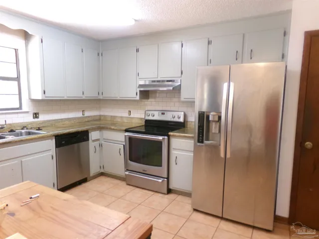 a kitchen with a stove sink and refrigerator