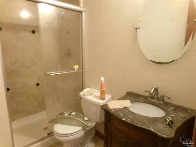 a bathroom with a granite countertop sink toilet a mirror and shower