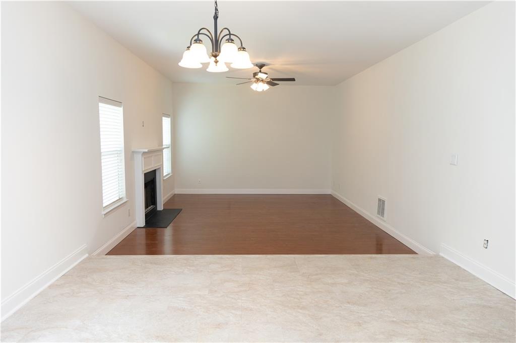 502 Streamside Place Canton, GA 30115 - Photo 11 of 33 an empty room with a chandelier fan and windows