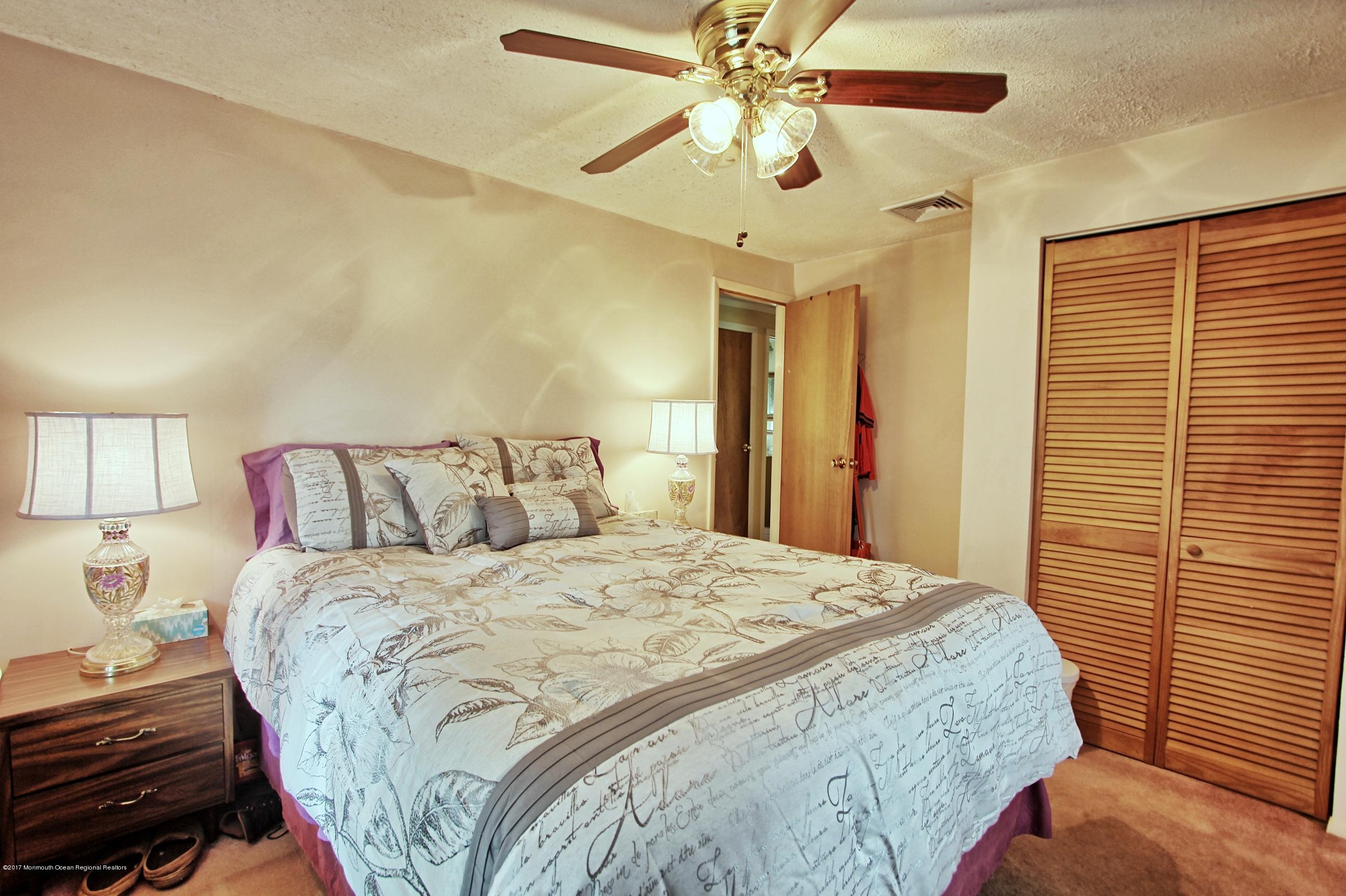 49 Siloam Road Freehold, NJ 07728 - Photo 13 of 38 a bedroom with a bed and a chandelier