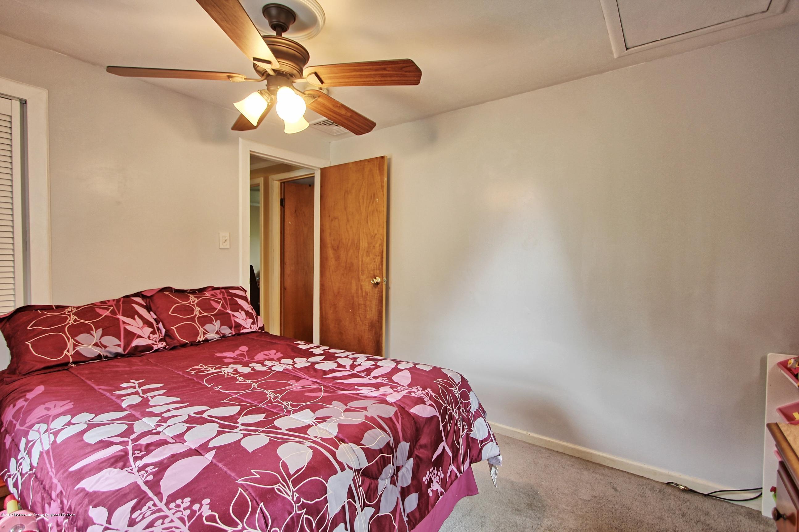49 Siloam Road Freehold, NJ 07728 - Photo 15 of 38 a bedroom with a large bed and a chandelier