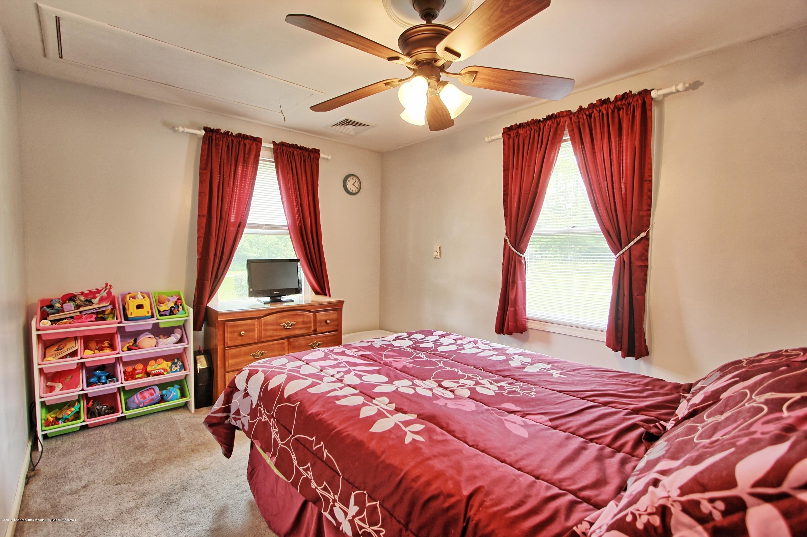 49 Siloam Road Freehold, NJ 07728 - Photo 16 of 38 a bedroom with a bed and a chandelier