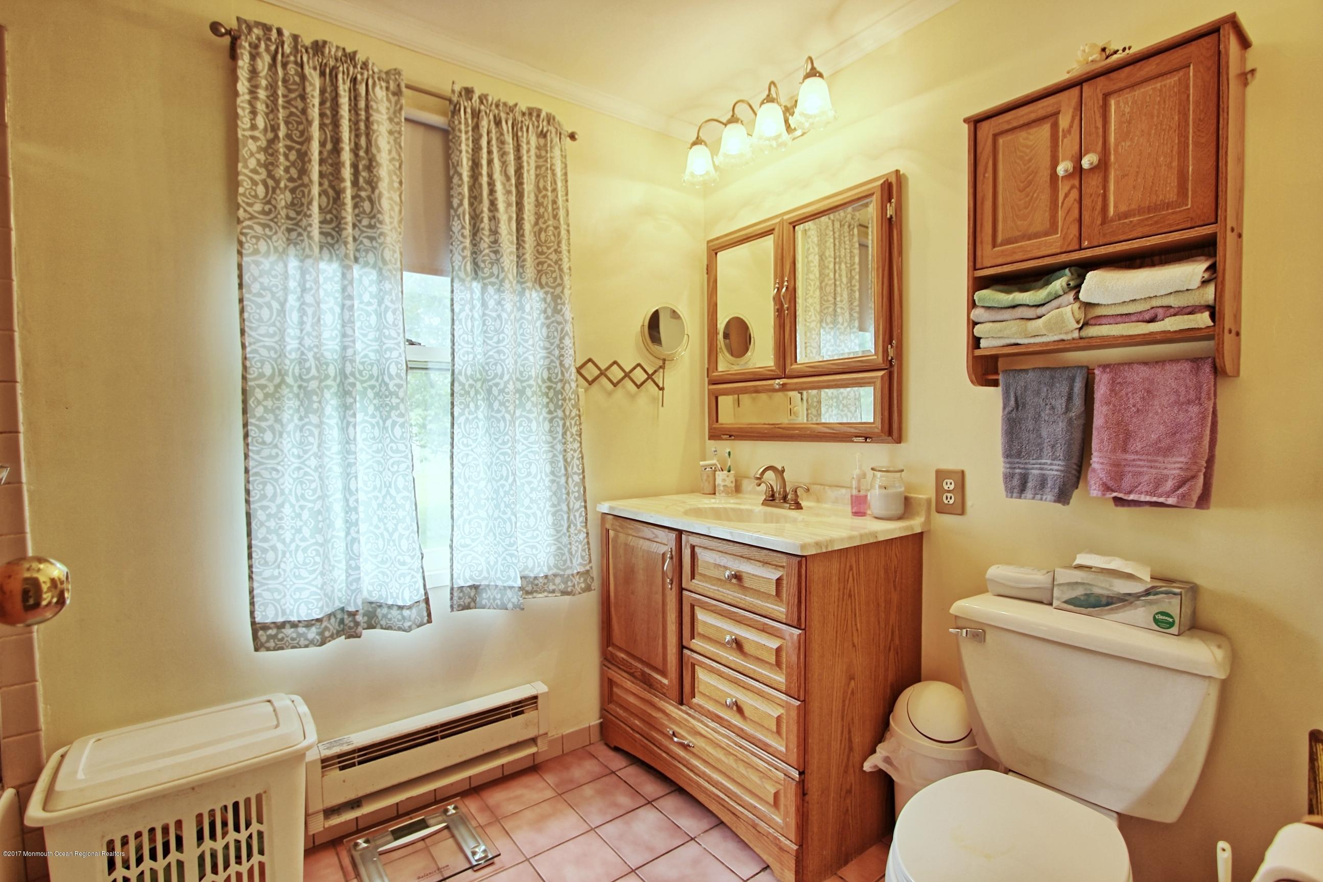 49 Siloam Road Freehold, NJ 07728 - Photo 19 of 38 a bathroom with a sink toilet mirror and tub