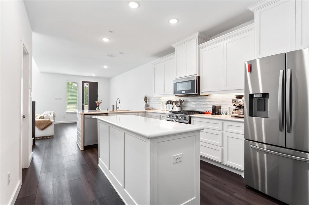 1737 Dalhart Road Plano, TX 75075 - Photo 9 of 28 a kitchen with white cabinets and stainless steel appliances
