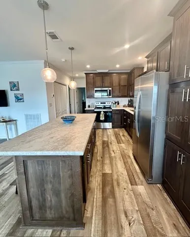 a kitchen with stainless steel appliances granite countertop wooden cabinets a stove top oven a sink and dishwasher