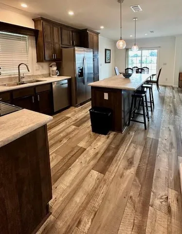 a living room with furniture a rug potted plant and a window