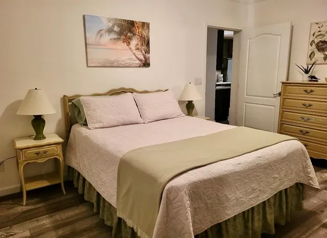 a bedroom with a bed and a flat tv screen on dresser