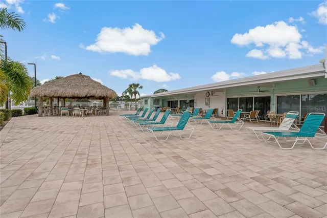 a view of a swimming pool with a patio and a yard