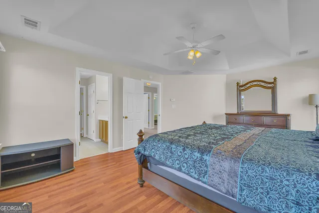 a bedroom with a bed and wooden floor