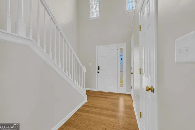 a view of a hallway with wooden floor and entryway