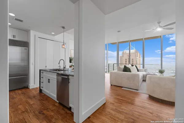 a large kitchen with stainless steel appliances granite countertop a refrigerator and a stove top oven
