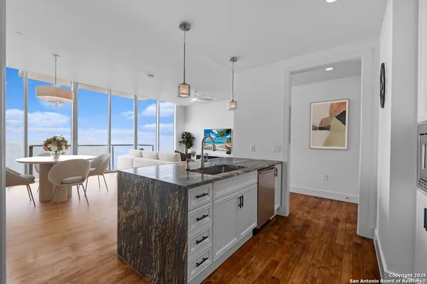 a kitchen with stainless steel appliances granite countertop a stove and a wooden floors