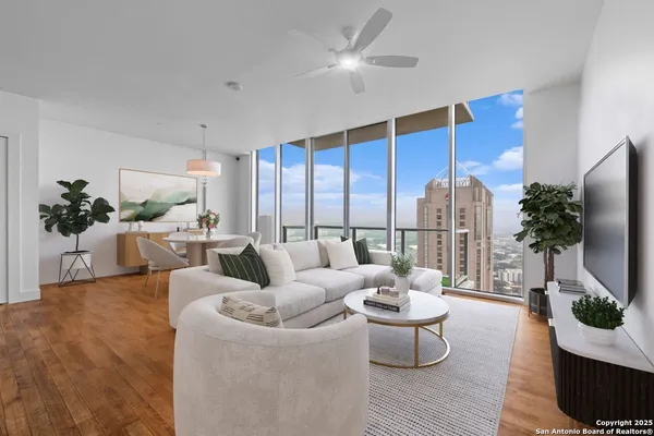 a living room with furniture potted plant and a large window