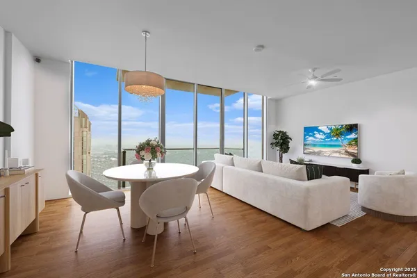 a living room with furniture a dining table and a floor to ceiling window