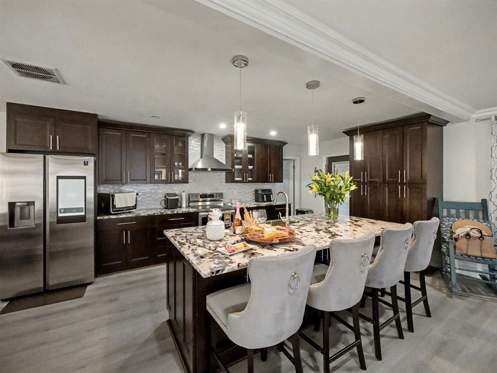 1255 Northwest 63rd Way Margate, FL 33063 - Photo 11 of 33 a kitchen with a refrigerator a kitchen island a stove a table and chairs
