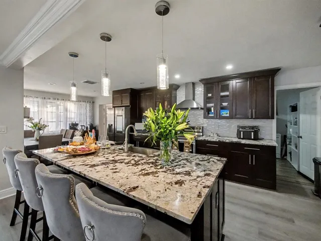 a kitchen with kitchen island granite countertop wooden cabinets and refrigerator