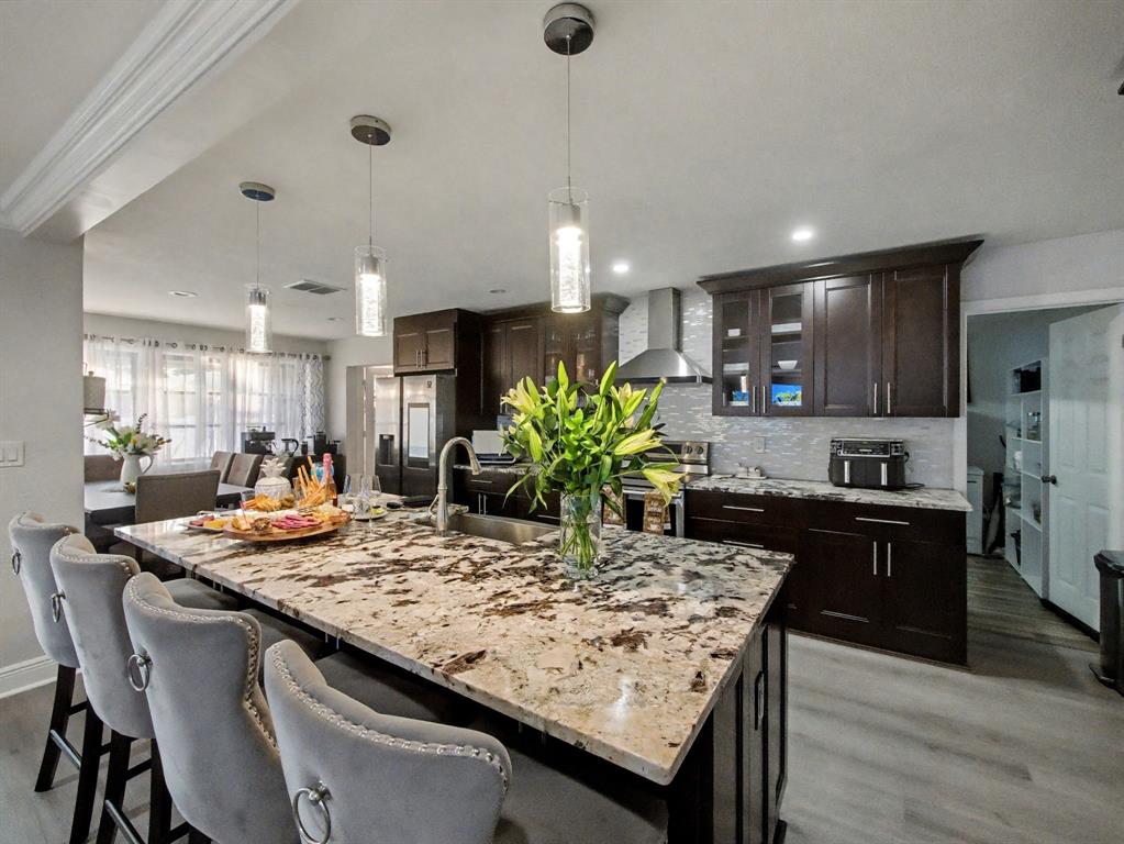 1255 Northwest 63rd Way Margate, FL 33063 - Photo 12 of 33 a kitchen with kitchen island granite countertop wooden cabinets and refrigerator