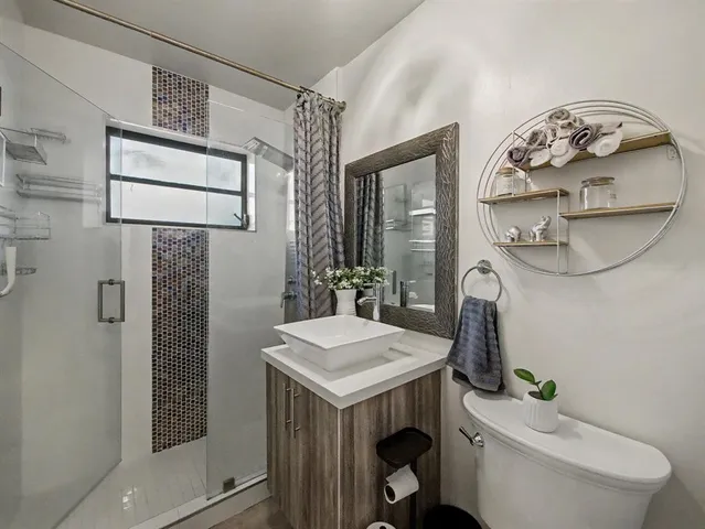 a bathroom with a toilet a sink and mirror